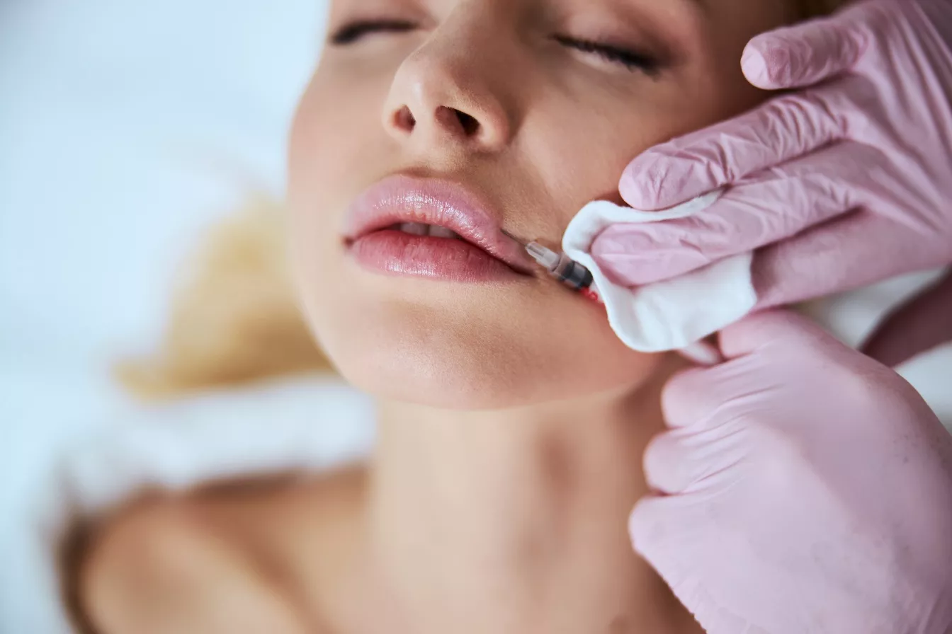 Cosmetician in latex gloves injecting the dermal filler into the woman's lips in Cincinnati OH | Clear Eyes + Aesthetics